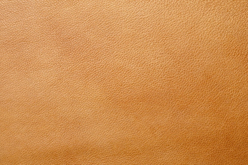 Close-up of a brown leather surface showcasing its texture.