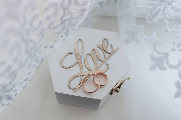 istock Wedding rings stand on a wooden box on a white background 2034080932