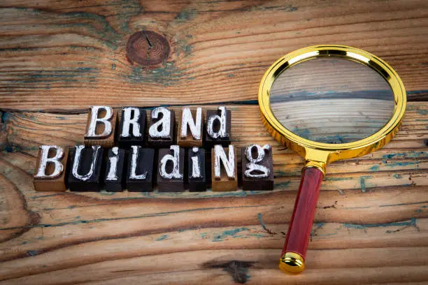 Photo of BRAND BUILDING. Alphabet letters on wood texture background