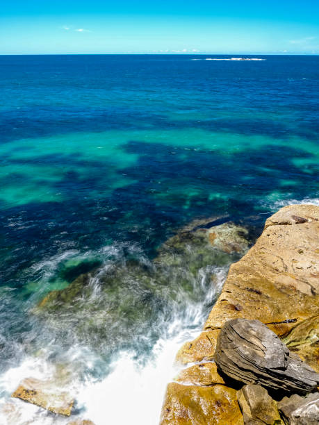 istock Powerful white swirling waves (blurred motion) crashing into coastline rocks 2034131243