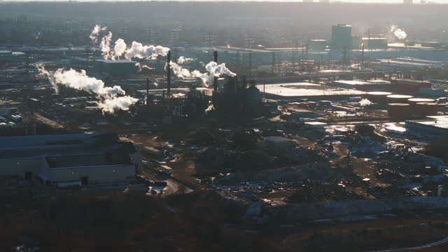 Industrial complex with smokestacks during winter, early morning light