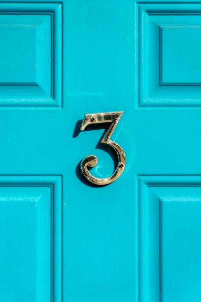 istock Brass number three on a teal door with reflection and shadow 2034181891