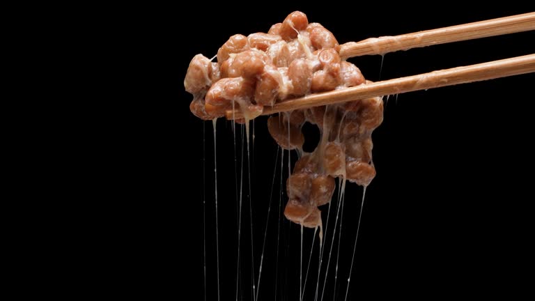 4K slow motion video of natto falling off chopsticks.