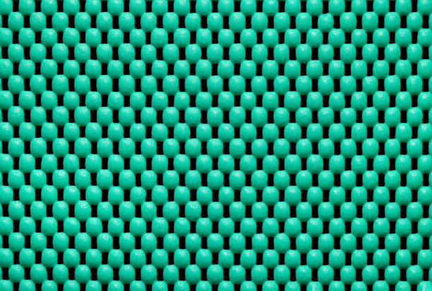 A fragment of a plastic rug, as a background or texture, green color, close-up.