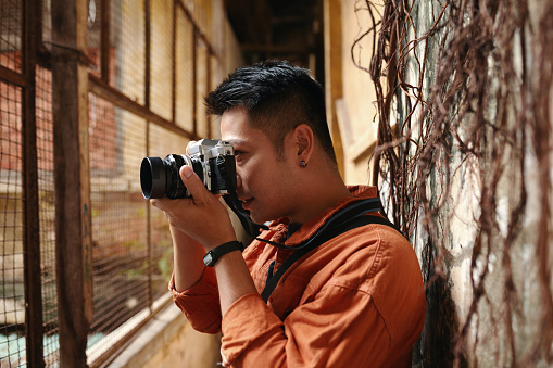 Man photographing fenced patio of old abandoned building