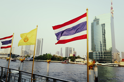 Along the banks of the Chao Phraya River lies one of Bangkok's busiest commercial districts, where the Thai national flag gently flutters in the breeze. Skyscrapers and bustling streets form a unique urban landscape, while the Thai flag symbolizes the pride and glory of the nation. Captured with the Leica Q3.