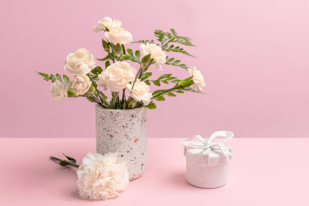 istock Bouquet of carnations in a vase with a gift box. 2034585692