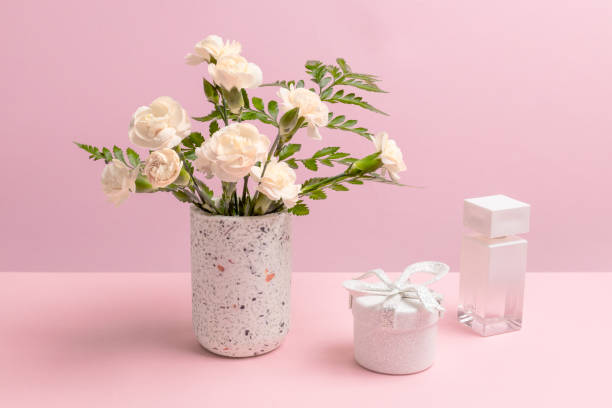 istock Bouquet of carnations in a vase with a gift box and a perfume. 2034586208