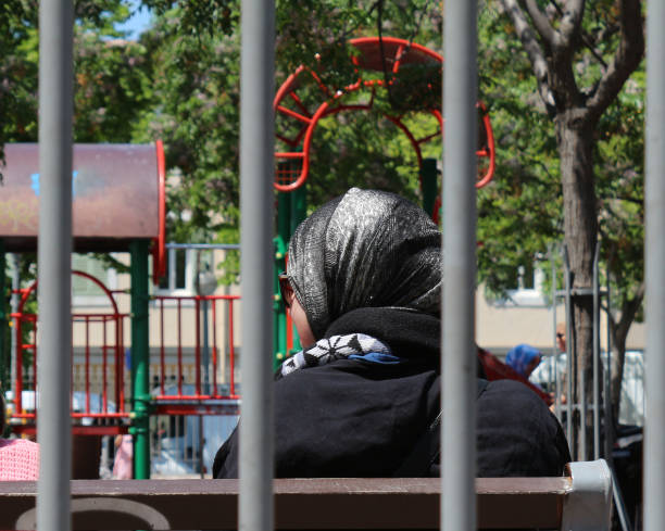 Marseille, France, 05 14 2023 : Muslim woman behind metallic bars.