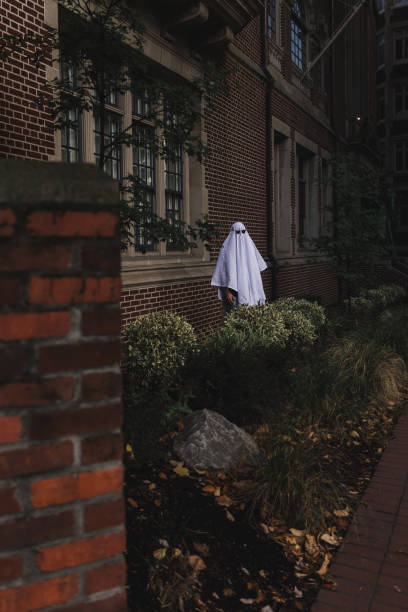 istock Spooky Halloween Ghost Outside of Old Brick Building 2034630671