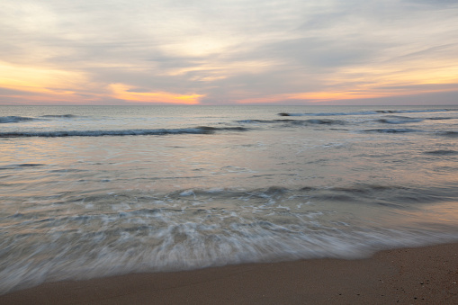 A scenic sunrise view of a beach on the Outer Banks in Nags Head, North Carolina.