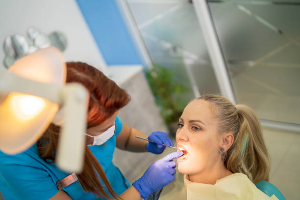 istock Young woman having her teeth checked during appointment at dentist's office. s 2034666282