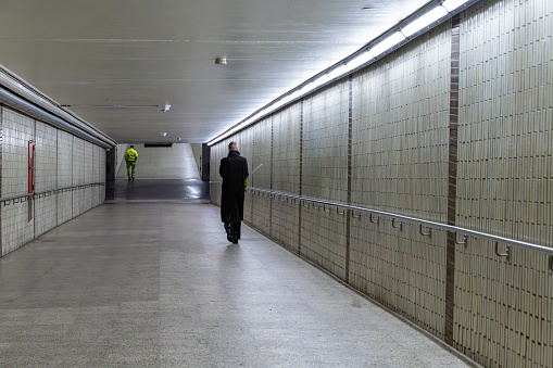 Stockholm, Sweden Feb 7, 2024 A man walks in a tunnel  in the Midsommarkransen Tunnelbanna or Metro station at night.