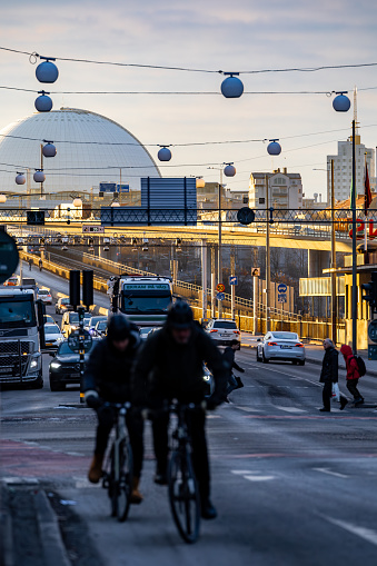 Stockholm, Sweden Feb 8, 2024 Pedestrian, bike, and car traffic in the Skanstull district and the Globe Arena in the background.