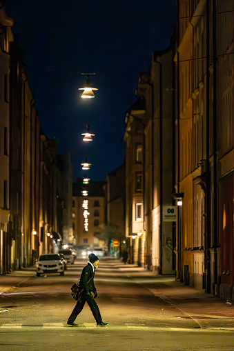 Stockholm, Sweden Feb 8, 2024 A pedestrian walks at night on Kocksgatan in the Sodermalm district.