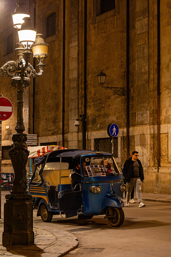 Palermo, Sicily, Italy Jan 19, 2024 A scooter taxi at night on Via Maqueda and pedestrians.