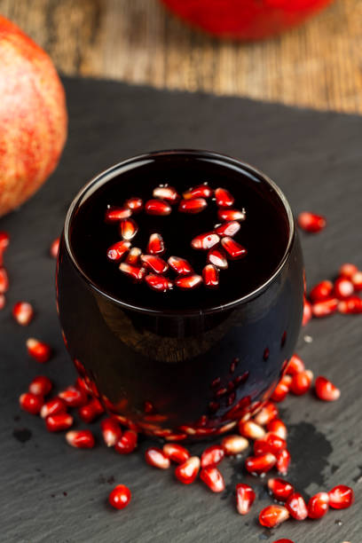 red ripe pomegranate and pomegranate juice on the table, tart pomegranate juice and red pomegranate close-up