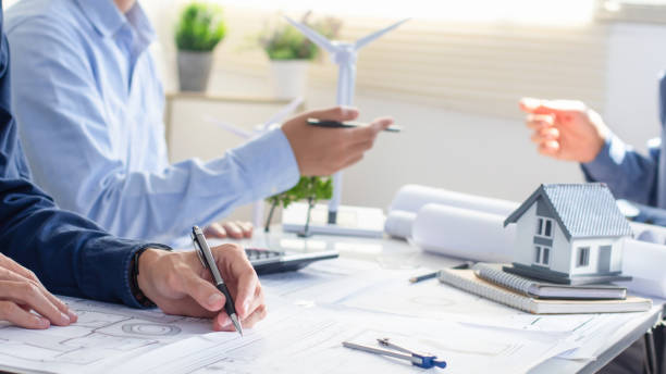 istock Architect planning meeting to work on plan with wind turbine model. clean energy and sustainability planning. Engineering, construction project and architect job with eco friendly. green business. 2034717528