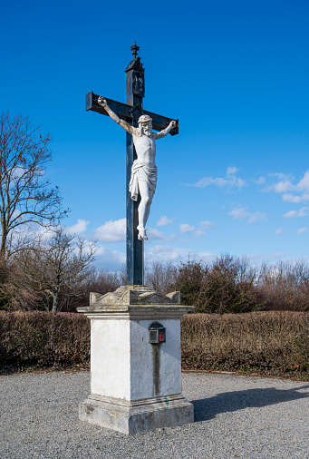 Statue of Christ on cross with concrete base.