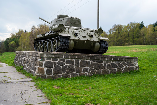 Soviet t-34 tank in a meadow on a concrete base.