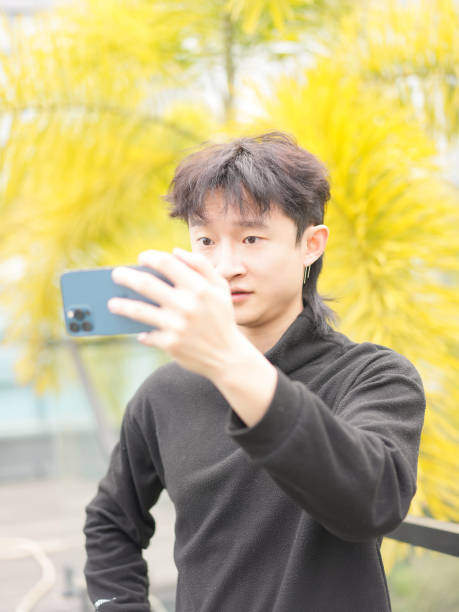 istock Asian man taking photo with smartphone 2034799090