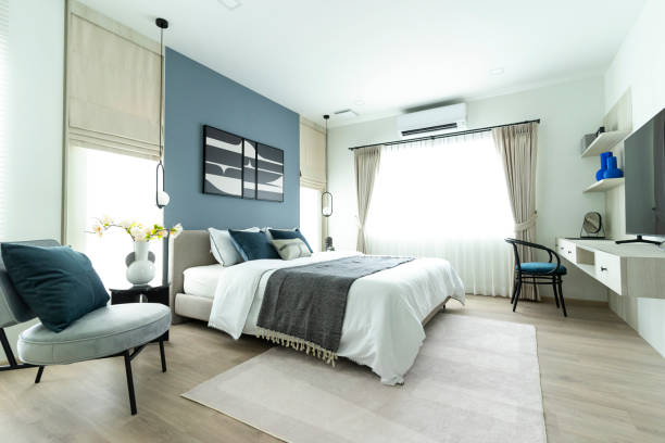 Stylish Bedroom with gray fabric headboard and bed with soft blue and white pillows