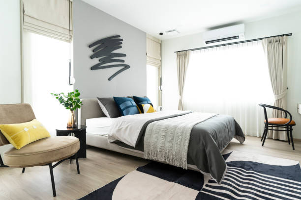 istock Stylish Bedroom with gray fabric headboard and bed with soft blue and white pillows 2034832549