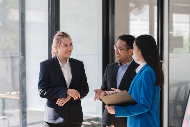 istock Asian business team standing in the office, having a conversation with each other. 2034833062