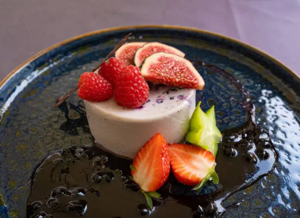 Blueberry Panna Cotta, Fruit Pannacotta, Creamy Italian Dessert, Panacotta with Figs, Raspberries, Strawberries and Chocolate Decoration on a Restaurant Plate