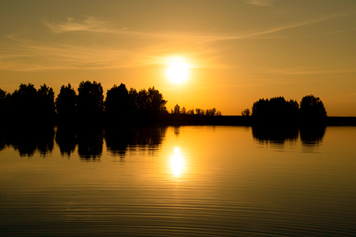 The scenic orange sunset at the lake in a spring