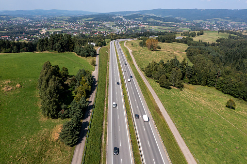 Aerial view of a highway among green hills in summer.