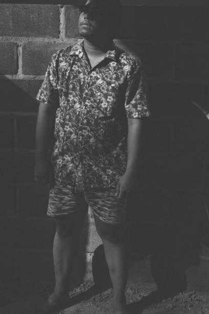 Portrait Of Boy Standing With Hands In Pockets On Field Against Old Ruins