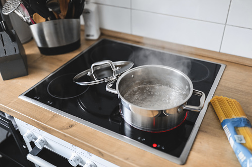 Pot with boiling water on the cooking plate. Cooking pasta or soup