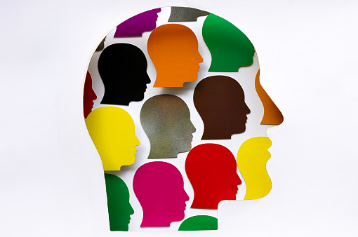 Paper head silhouette filled with multicolored head shapes.