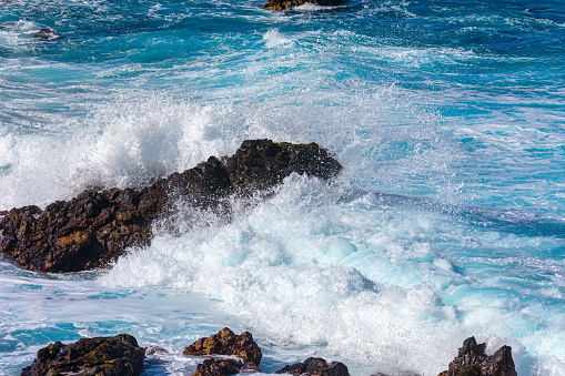 Waves breaking on the rocks on the coast of the island of Madeira