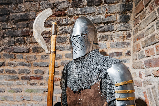 Medieval knight in full armor with weapon in fortress
