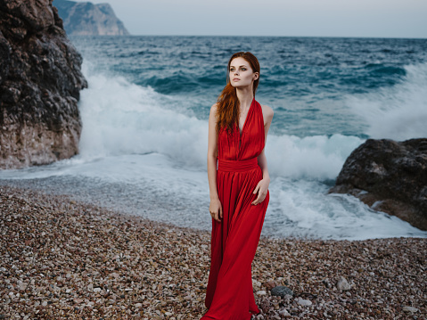 woman in red dress shore oceans posing fashion silhouette. High quality photo