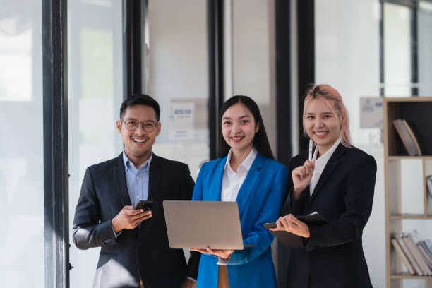 istock Young successful colleagues discussing business plan over laptop while standing in the meeting room. 2034933939