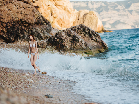 Woman in white swimsuit by the ocean posing vacation tropics travel. High quality photo