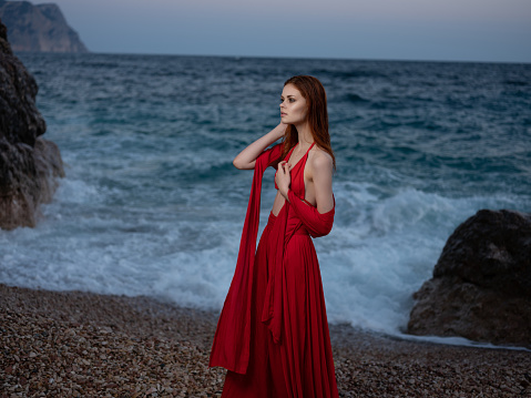 pretty woman in red dress posing luxury ocean beach lifestyle. High quality photo