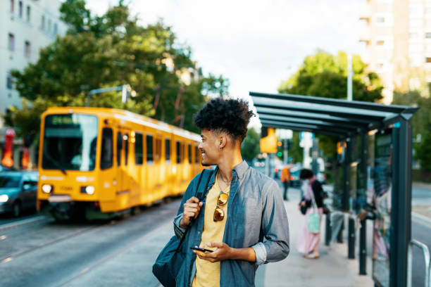istock African American commuter in the city, using smart phone while waiting for the tram 2034990681