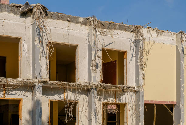 demolition of a large old historic stone house in the city, new multi-storey buildings in the background, brick pile in the foreground