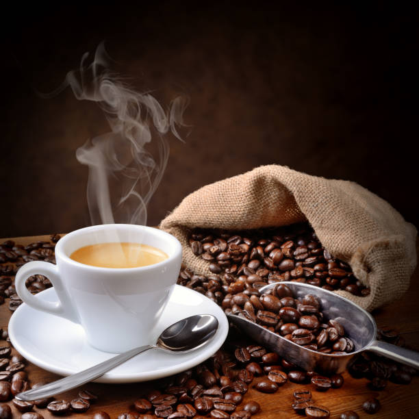 istock Steaming espresso and coffee beans on wooden table, space for text. 2035031308