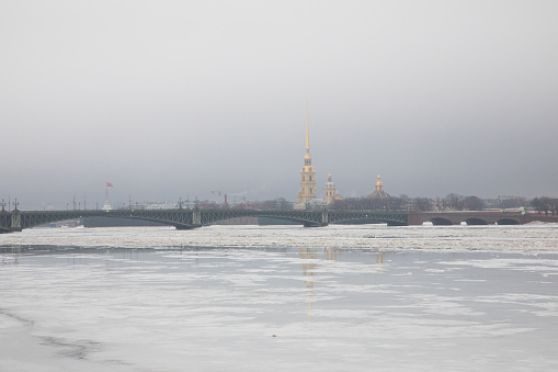 Ulyanovsk, Russia - January 6, 2022: An ice making resurfacer machine (filling machine) cruises by on the ice skating rink against the backdrop of Christmas decorations and twinkling garlands.