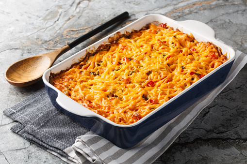 King Ranch Casserole layers of juicy chicken, corn tortillas and cheese enveloped in a cream sauce with tomatoes, bell peppers and green chiles close-up in a baking dish. Horizontal