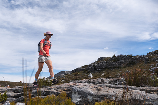 A woman enjoys an adventurous hike through in the rocky mountains of the Cederberg Mountain range near Cape Town, South Africa