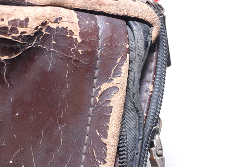 The surface of a used leather bag that has begun to peel begins to turn brown due to too much exposure to rain and heat