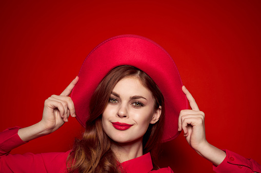 beautiful elegant woman in red hat bright makeup studio model. High quality photo