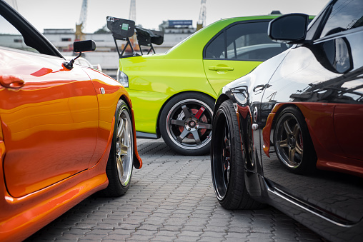 Odesa, Ukraine - May 07 2016: JDM car meet - Japanese cars owners gathering - orange Toyota Supra, Back Nissan 350z and lime Green Mitsubishi Lancer Evo.