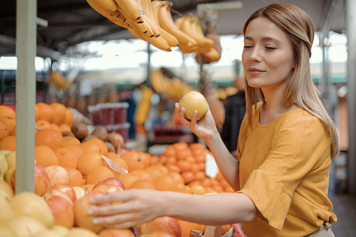 Woman choosing fruits and vegetables at food market